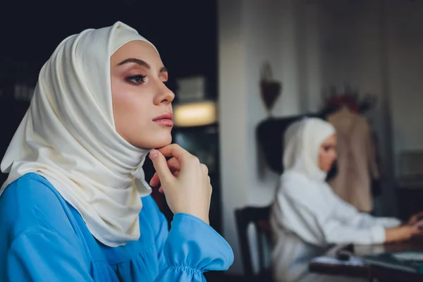 Porträt einer schönen asiatischen muslimischen Frau Modell trägt weiße Bluse und blauen Hijab posiert auf weißem Vorhang als Hintergrund in Nahaufnahme. — Stockfoto
