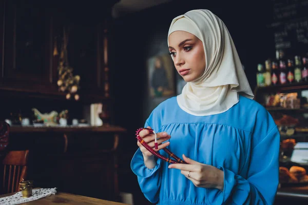 Religiosa budista asiática rezando con la mano sosteniendo cuentas de rosario. Discípula budista femenina meditando, cantando mantra con rosario oración en la mano a la estatua del Señor Buda en la sala del templo —  Fotos de Stock