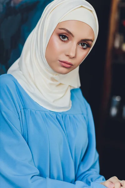 Retrato de una hermosa mujer musulmana asiática modelo con blusa blanca y hiyab azul posando sobre una cortina blanca como fondo en vista de cerca. —  Fotos de Stock