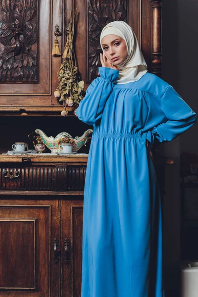 Retrato de una hermosa mujer musulmana asiática modelo con blusa blanca y hiyab azul posando sobre una cortina blanca como fondo en vista de cerca. —  Fotos de Stock