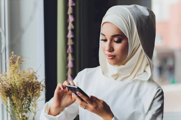 Muslimische Frau telefoniert in einem Café. — Stockfoto