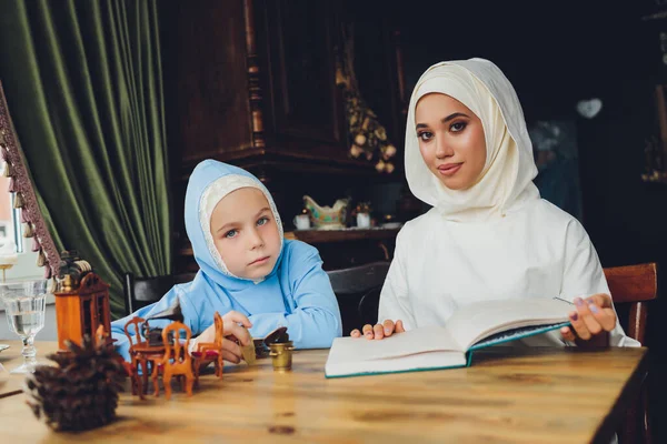 Seitenporträt eines kleinen muslimischen Mädchens, das einen blauen Hijab trägt. Konzept muslimischer Kleidung für Kinder. — Stockfoto