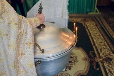 Bebeği kilisede yıkamak için yazı tipine su dökülüyor, dini gelenekler..