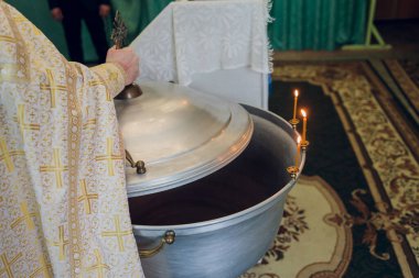 Bebeği kilisede yıkamak için yazı tipine su dökülüyor, dini gelenekler..