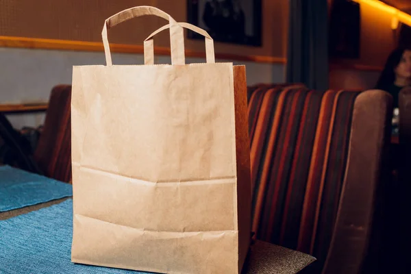 Dessertpapieren zak voor de klant klaar op de toonbank in moderne cafe coffeeshop, levering van voedsel, cafe restaurant, afhaalmaaltijden. — Stockfoto