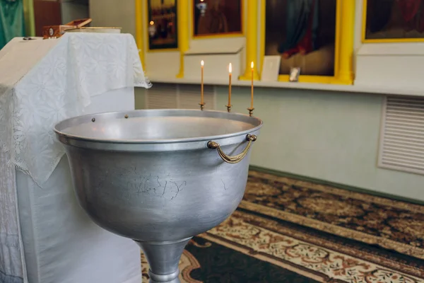 Woda jest wlewana do czcionki do kąpieli dziecka w kościele, tradycje religijne. — Zdjęcie stockowe