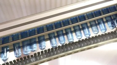 Plastik endüstrisi: Endüstriyel üretim fabrikasındaki üretim hattındaki şişeler için küçük kahverengi plastik bankalar.