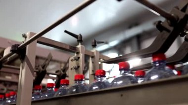 İçki fabrikasının konveyör bandındaki yeni plastik şişeler..