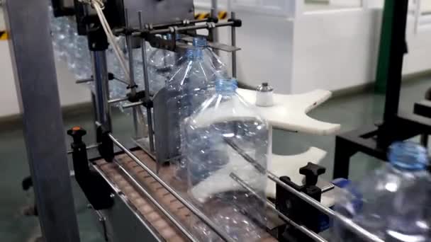 Production de fluides techniques. Mécanisme industriel automatisé pour préparer des bouteilles en plastique. Ligne de production de produits chimiques. Rangée de bouteilles en plastique se déplace le long du Converyor Gros plan. — Video