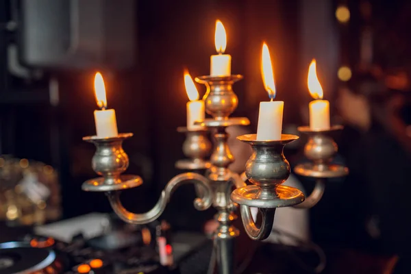 Metalen retro kandelaar met vijf brandende kaarsen tegen een donkere achtergrond in de kamer huis, selectieve focus. — Stockfoto