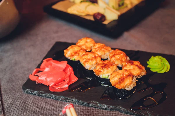 Çeşitli suşi ve tahtanın üzerine yerleştirilmiş ruloların üstünde. Japon yemek festivali. Üst manzara, düz uzanma. — Stok fotoğraf