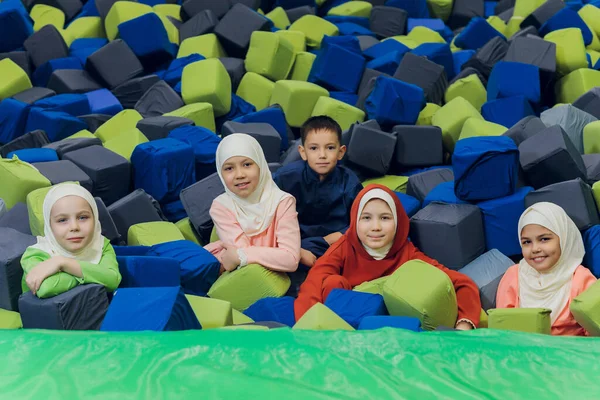 Kinder in muslimischen Kleidern springen in weichen Würfeln. — Stockfoto