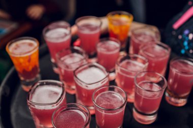 Bar tezgahında servis edilen sert alkollü içkilerin çeşitleri. Arka planda bulanık şişeler.