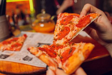 İki el, karton bir kutudan pizza dilimleri alıyor..