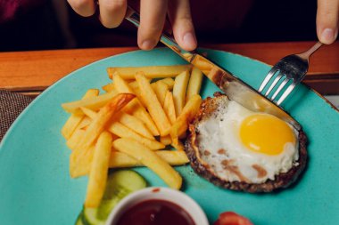Izgara biftek, patates kızartması, kızarmış yumurta ve sebze..