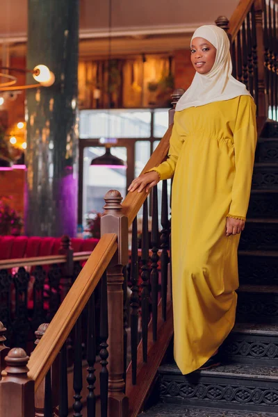 Mooi moslim meisje in hijab glimlachen, wachten op haar eten in een restaurant. — Stockfoto