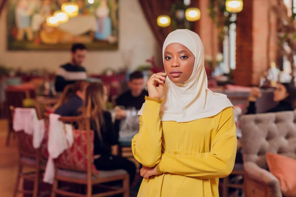 Mooi moslim meisje in hijab glimlachen, wachten op haar eten in een restaurant. — Stockfoto