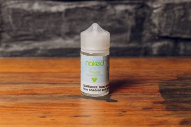 Ufa, Rusya, 5 Temmuz 2020: E-likit e-meyve suyu Elektronik sigara buharlaştırma cihazı için yüksek buhar, şişe içinde vape bar tezgahında duman buharı. Çıplak marka.