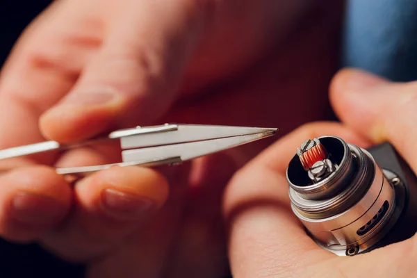 Spezialist ersetzt Feder für das Rauchen von Dampf.Professionelle Aufrechterhaltung der elektronischen Zigarette im Laden.Reparieren defekte Dampfgerät und das Rauchen von Nikotinzigaretten beenden. — Stockfoto