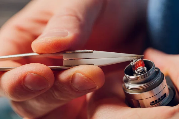 Spezialist ersetzt Feder für das Rauchen von Dampf.Professionelle Aufrechterhaltung der elektronischen Zigarette im Laden.Reparieren defekte Dampfgerät und das Rauchen von Nikotinzigaretten beenden. — Stockfoto