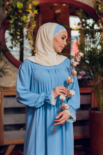 Hermosa chica musulmana en hijab sonriendo, esperando su comida en un restaurante. — Foto de Stock