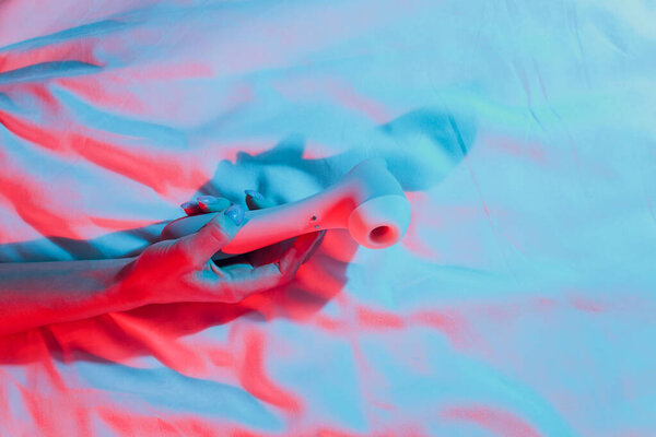 Contactless Clitoral Stimulator Woman in bedroom holding vibrator in hand.