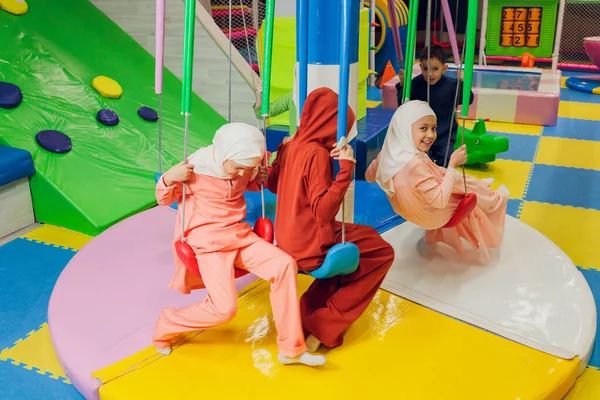 Kinder in muslimischen Kleidern fahren Schaukel. — Stockfoto