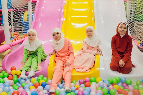 Kinder in muslimischen Kleidern springen auf einer Kinderrutsche. — Stockfoto