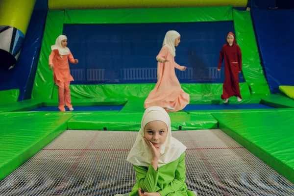 Kinder in muslimischen Kleidern springen auf einem Trampolin. — Stockfoto