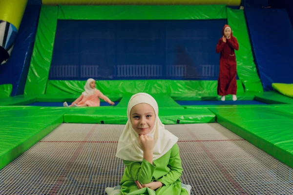 Kinder in muslimischen Kleidern springen auf einem Trampolin. — Stockfoto