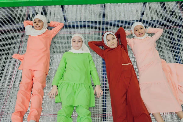 Kinder in muslimischen Kleidern springen auf einem Trampolin. — Stockfoto