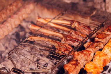 Metal şişte pişen ızgara kebap. Barbeküde pişmiş et. Barbekü taze et dilimleri. Geleneksel doğu yemeği, şiş kebap. Kömür ve alevler üzerine ızgara, piknik, sokak yemekleri.