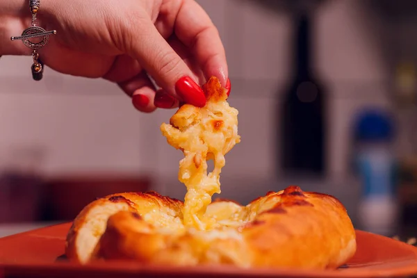 Woman is eating adjarian khachapuri with hands, crushing egg yolk. — Stock Photo, Image