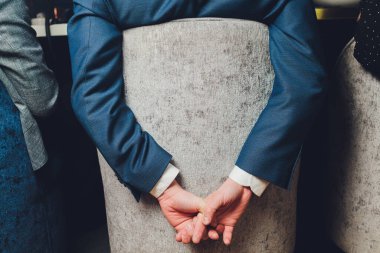 Yorgun siyah işadamının ellerini çapraz yapıp zorlu bir iş gününden sonra geriye doğru uzandığı arka manzara..