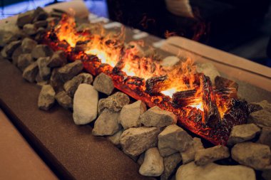 Elektrikli şömineyi turuncu ve sarı alevlerle kapatın..