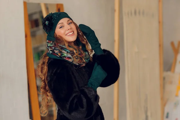 행복 한 아름다운 여성이 흥분 해서 옆을 바라보고 있습니다. 따뜻 한 모자를 쓰고 벙어리장갑을 낀 소녀. — 스톡 사진
