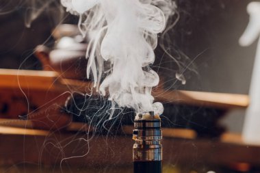 Vape spiral üzerinde gliserin sıçraması. Büyük sis bulutları ve görünür izleyiciler. Vape kültürü ve sigara içmek yasak..