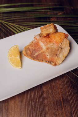 Siyah bir tabakta güzel kızarmış sazan parçaları..