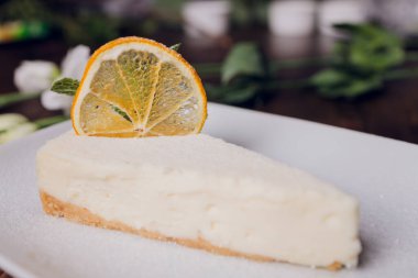 Beyaz ahşap arka planda bir fincan kahveli limonlu pasta..