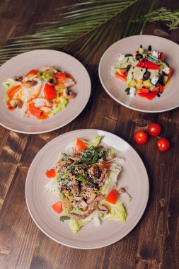 Karanlık bir arka planda salata seti. Yunan salatası, Sezar salatası, sebze salatası..