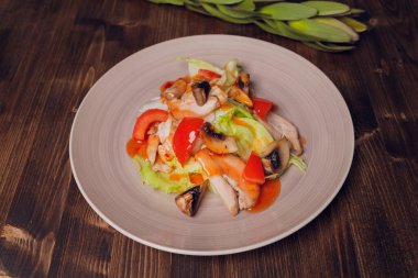 Ahşap masa zemininde çatallı cam tabakta Yunan salatası.