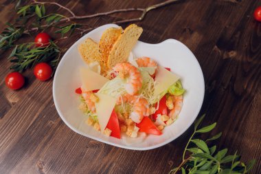 Tavuklu Sezar salatası, ahşap masada kızarmış ekmek ve sebze..