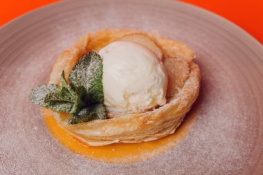 Turuncu arka planda dondurmalı tatlı pasta izole..