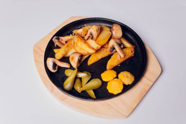 Beyaz arka planda tavada mantarlı kızarmış patates..