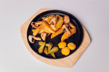 Beyaz arka planda tavada mantarlı kızarmış patates..