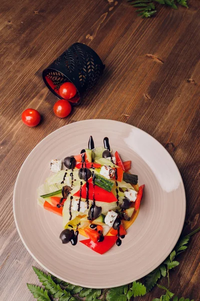 나무로 된 탁자 배경에 포크를 얹은 유리 접시에 놓인 그리스 샐러드. — 스톡 사진