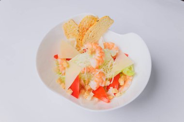 Tavuklu Sezar salatası ve beyaz arka planda yeşiller..