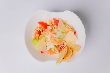 Tavuklu Sezar salatası ve beyaz arka planda yeşiller..