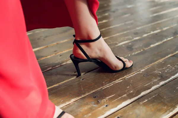 Bir kadının ayağı ayakkabının içinde, ahşap zemine sıkıştı. delik.