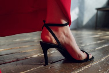 Bir kadının ayağı ayakkabının içinde, ahşap zemine sıkıştı. delik.